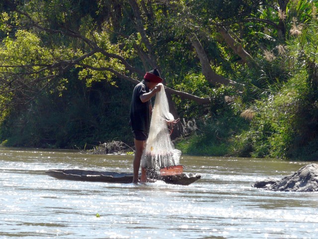 fisherman with cast net and small dugout